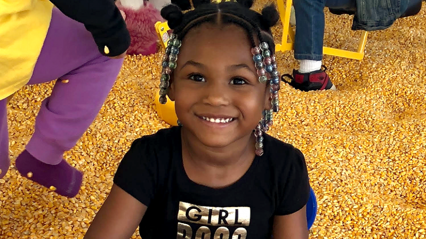 Closeup of grinning girl at the pumpkin patch.